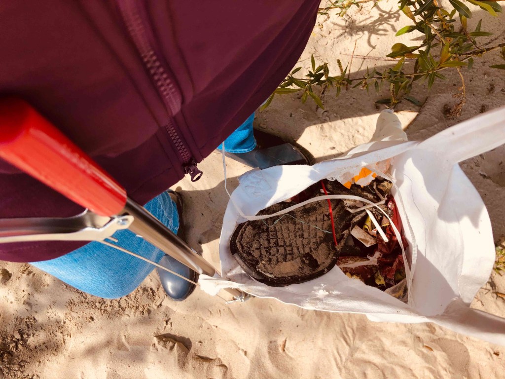 Am Strand Müll sammeln
